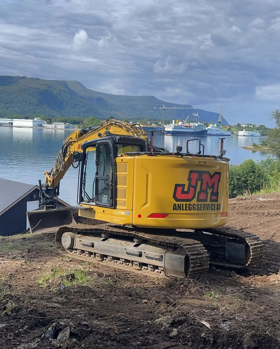 Gravemaskin fra JM Anleggservice på en ryddet skråning ved fjorden