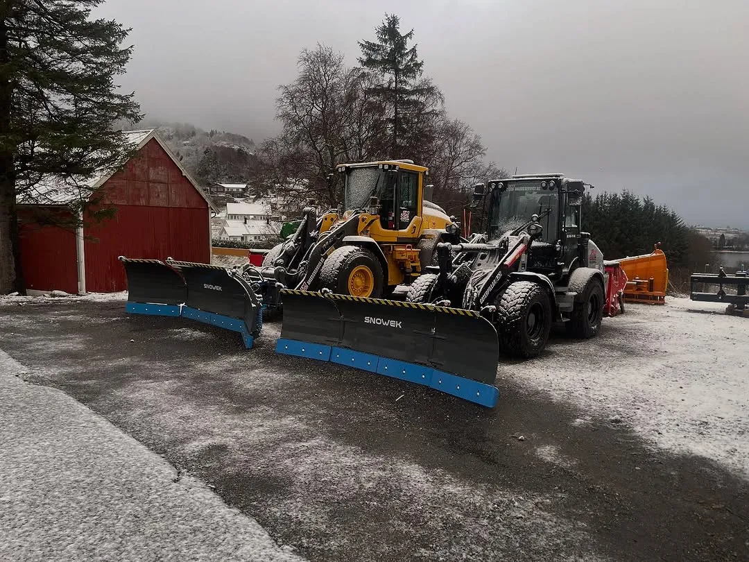 To hjullastere med brøyteplog, klare for vinteren