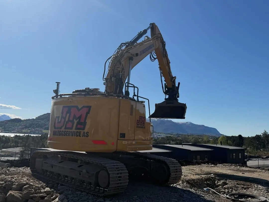 Gravemaskin fra JM Anleggservice med fjord og fjell i bakgrunnen