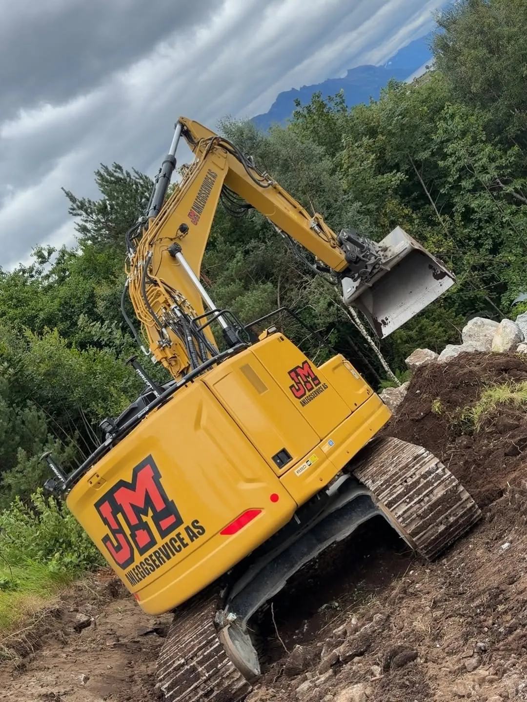 Gravemaskin fra JM Anleggservice i en bratt skråning